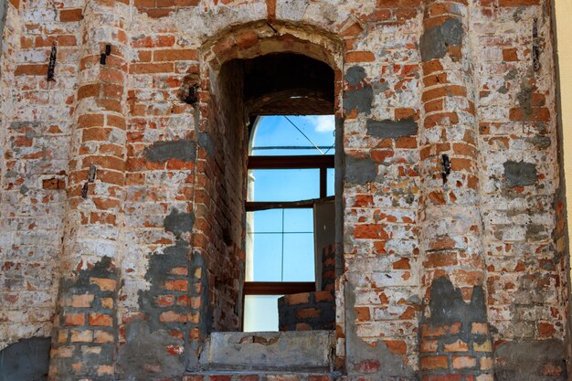 Ventana de arco en la pared de ladrillo rojo en un edificio antiguo