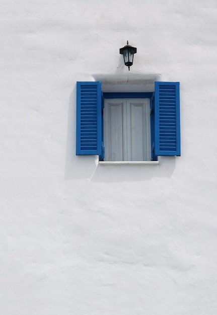 Ventana azul vintage en la pared blanca