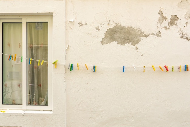 Ventana blanca y pared con pinza de tela de color