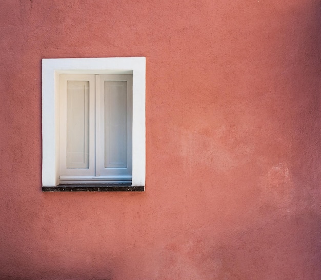 Ventana blanca en pared rosa