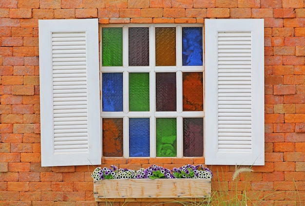 Ventana blanca vintage en pared de ladrillo rojo