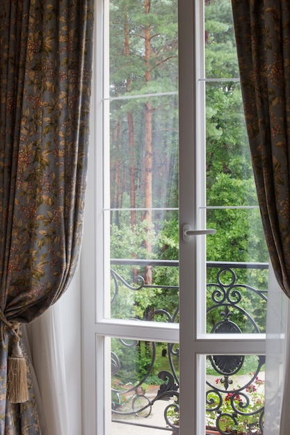 Ventana blanca con vista a madera verde