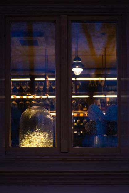 Foto ventana de un café desde la calle con decoraciones de año nuevo y un bar en el fondo