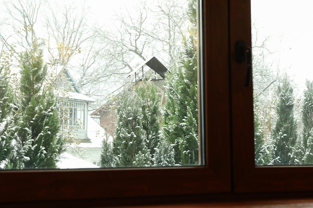 Ventana de casa con vista en día de nieve