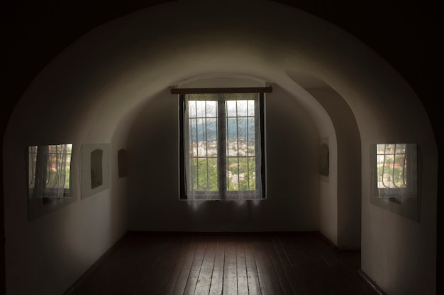 Ventana con celosía en una ventana arqueada en una habitación oscura