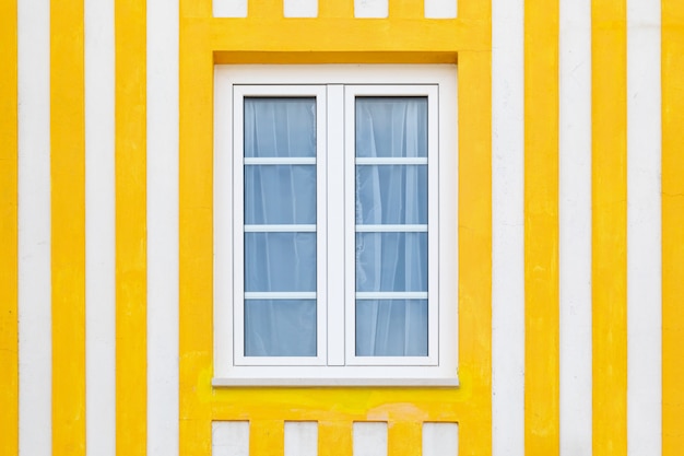 Foto ventana de color en la pequeña casa de madera típica con rayas de colores en costa nova, aveiro, portugal.