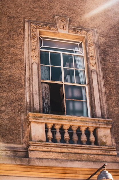 Foto una ventana en un edificio con un balcón en el centro.