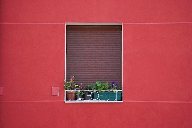ventana en la fachada roja de la casa en la ciudad