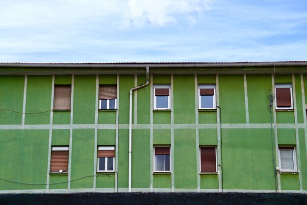 ventana en la fachada verde de la casa en la ciudad