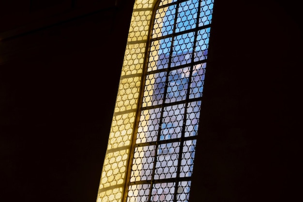 Ventana y una lámpara en el fondo negro de la iglesia católica alemana