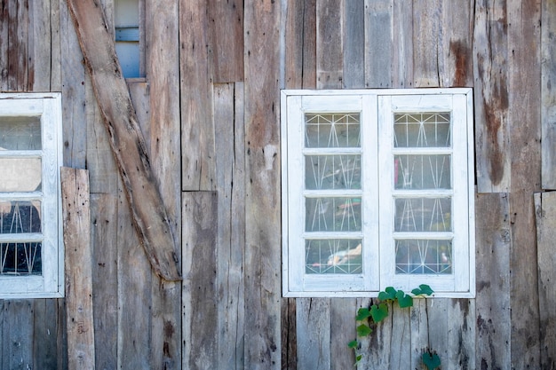 Ventana de madera blanca en la pared de una casa de madera vintage de diseño moderno para relajarse en armonía con la naturaleza