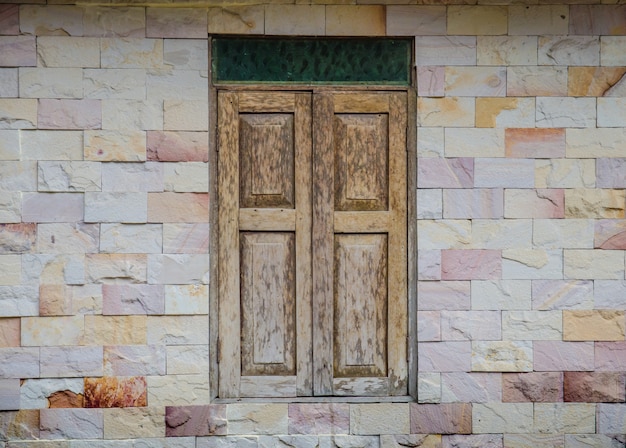 Foto ventana de madera en muro de piedra