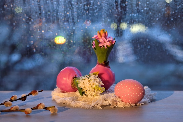 Ventana nocturna en jacinto de primavera con cebolla en cera y huevos de Pascua pintados y ramitas de sauce