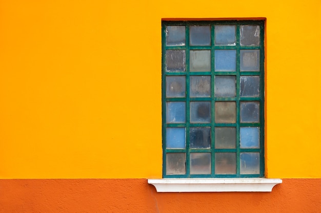 Foto ventana en la pared naranja de la casa. arquitectura colorida en la isla de burano, venecia, italia.