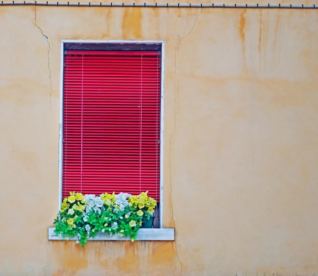 Ventana roja en una pared beige