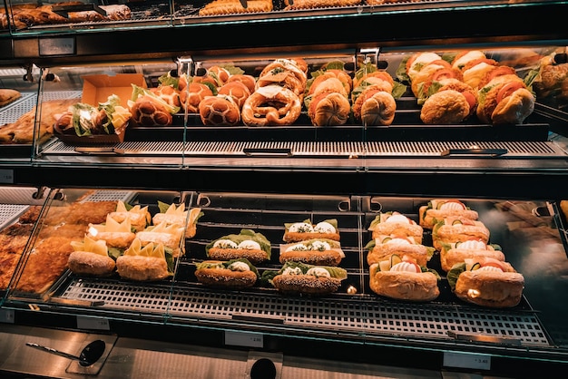 En la ventana de una tienda o supermercado se vende una variedad de sándwiches con varios rellenos Concepto de bocadillos y comida rápida