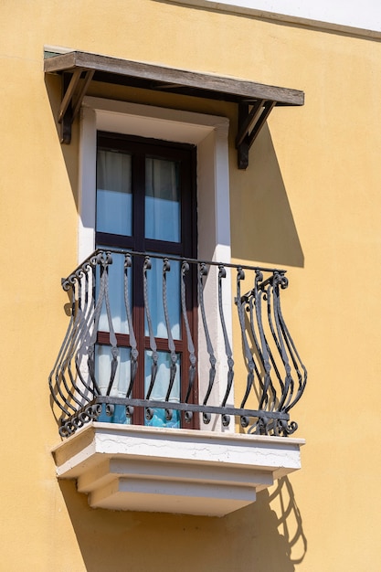 Ventanas con balcón en la fachada del edificio con adornos de hierro fundido en Bodrum, Turquía