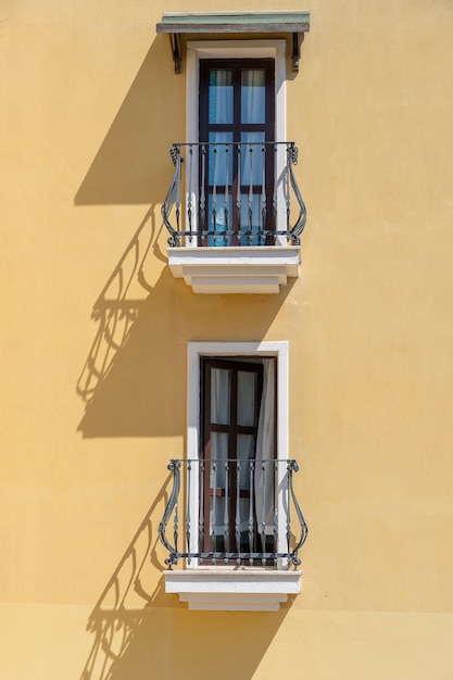 Ventanas con balcón en la fachada del edificio con adornos de hierro fundido