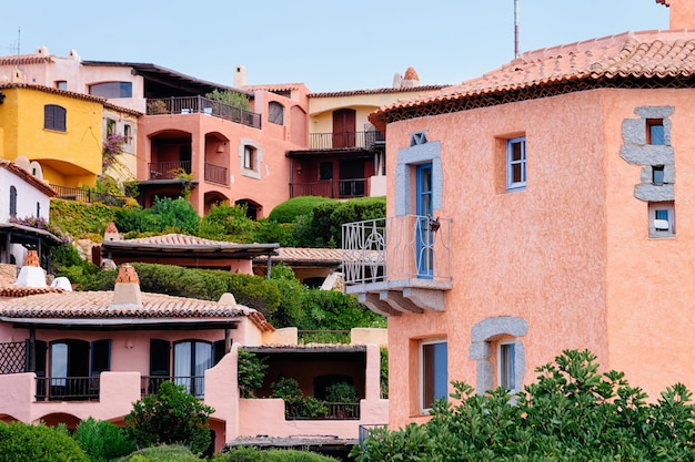 Ventanas y balcones del complejo de casas residenciales. Edificio de apartamentos. Arquitectura casera costera de la ciudad turística de lujo de Porto Cervo en la isla de Cerdeña, Italia en verano. Ciudad sarda en Cerdeña