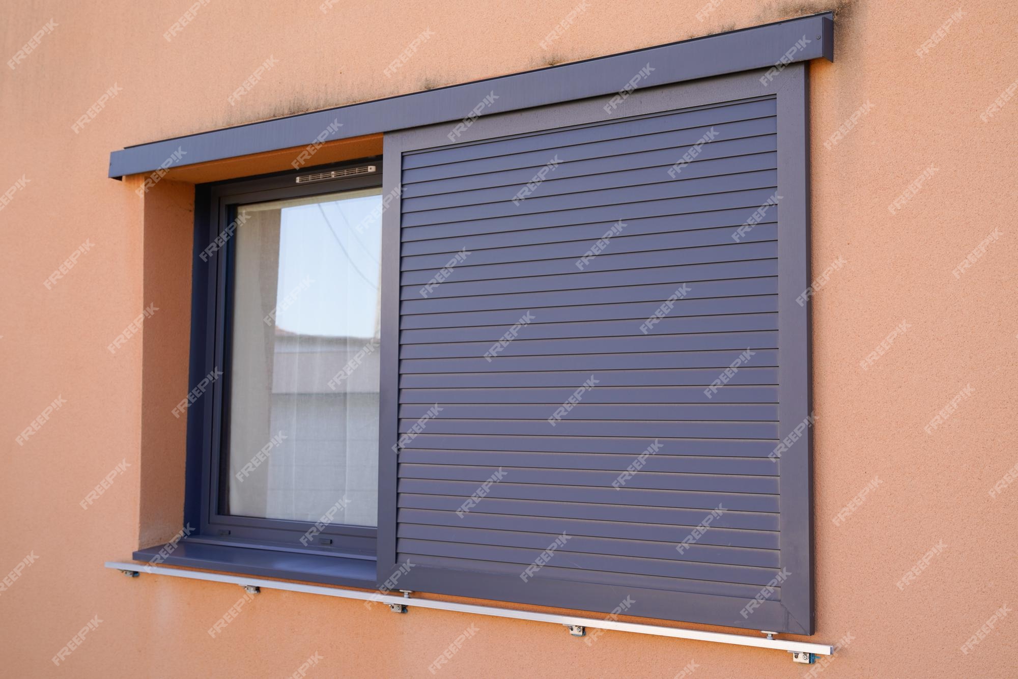 Ventanas de con persianas correderas modernas en la fachada de la casa | Foto
