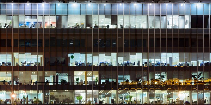 Foto ventanas de edificios de oficinas por la noche, la gente trabaja con el tiempo.
