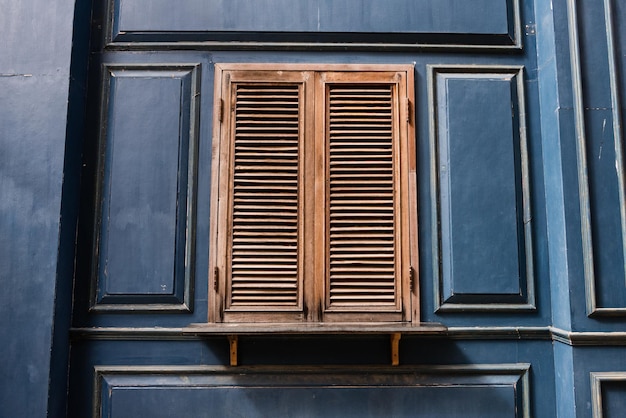 Ventanas de madera antiguas en la pared de madera azul