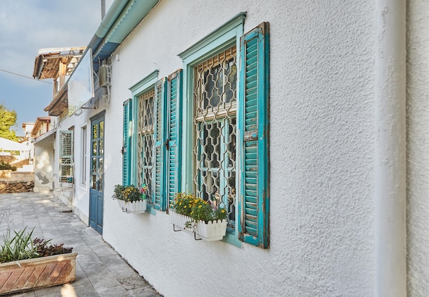 Ventanas y persianas de madera pintadas de azul en casa al atardecer