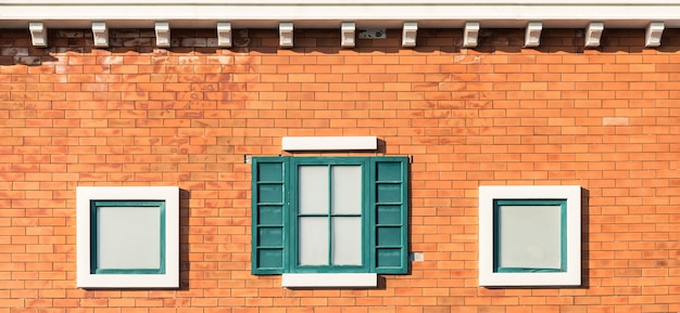 Ventanas de la vendimia en la pared anaranjada en el edificio.