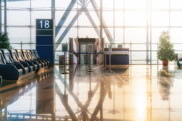 Ventanas de vidrio de piso a techo y sillones en el aeropuerto ter