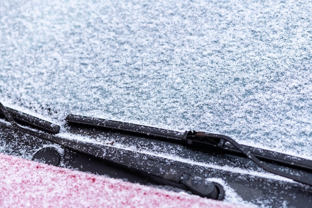 Ventanilla de coche cubierta de nieve con limpiaparabrisas