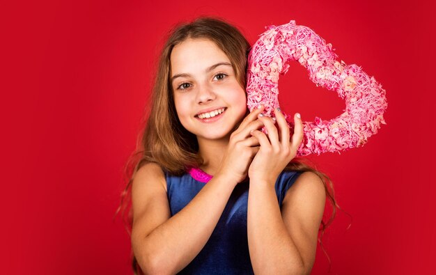 Ventas del día de san valentín niña feliz corazón decorativo día de san valentín el amor está en el aire niño pequeño fondo rojo regalo para vacaciones feliz día del niño tienda de decoración me encantan las vacaciones