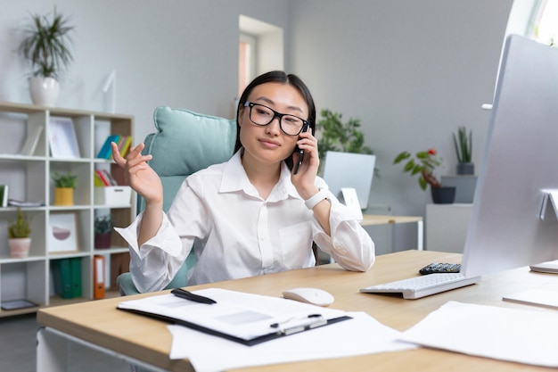 Ventas en línea, una joven y hermosa gerente de ventas asiática vende productos por teléfono llama a los clientes