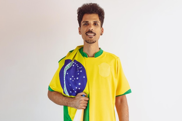 Ventilador de hombre negro brasileño con camiseta de equipo de fútbol aislado en blanco