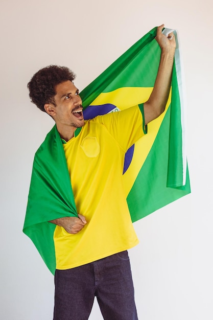 Ventilador de hombre negro brasileño con camiseta de equipo de fútbol aislado en blanco