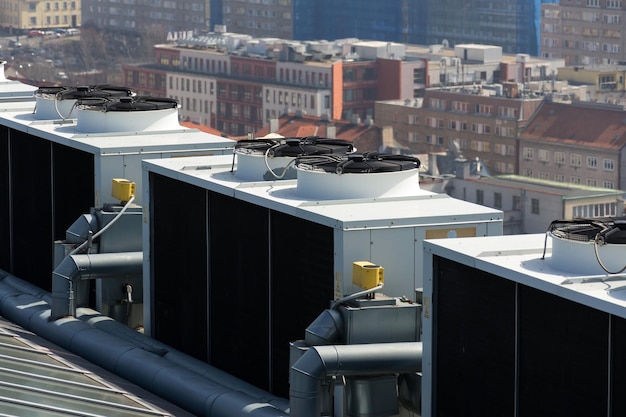 Foto ventiladores de ar condicionado no telhado com casas ao fundo