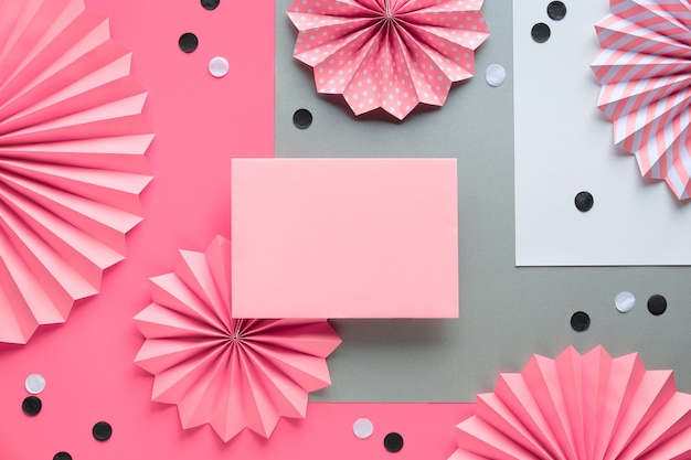 Ventiladores de círculo e confetes em fundo rosa. Quadro criativo para texto de saudação no cartão em branco.