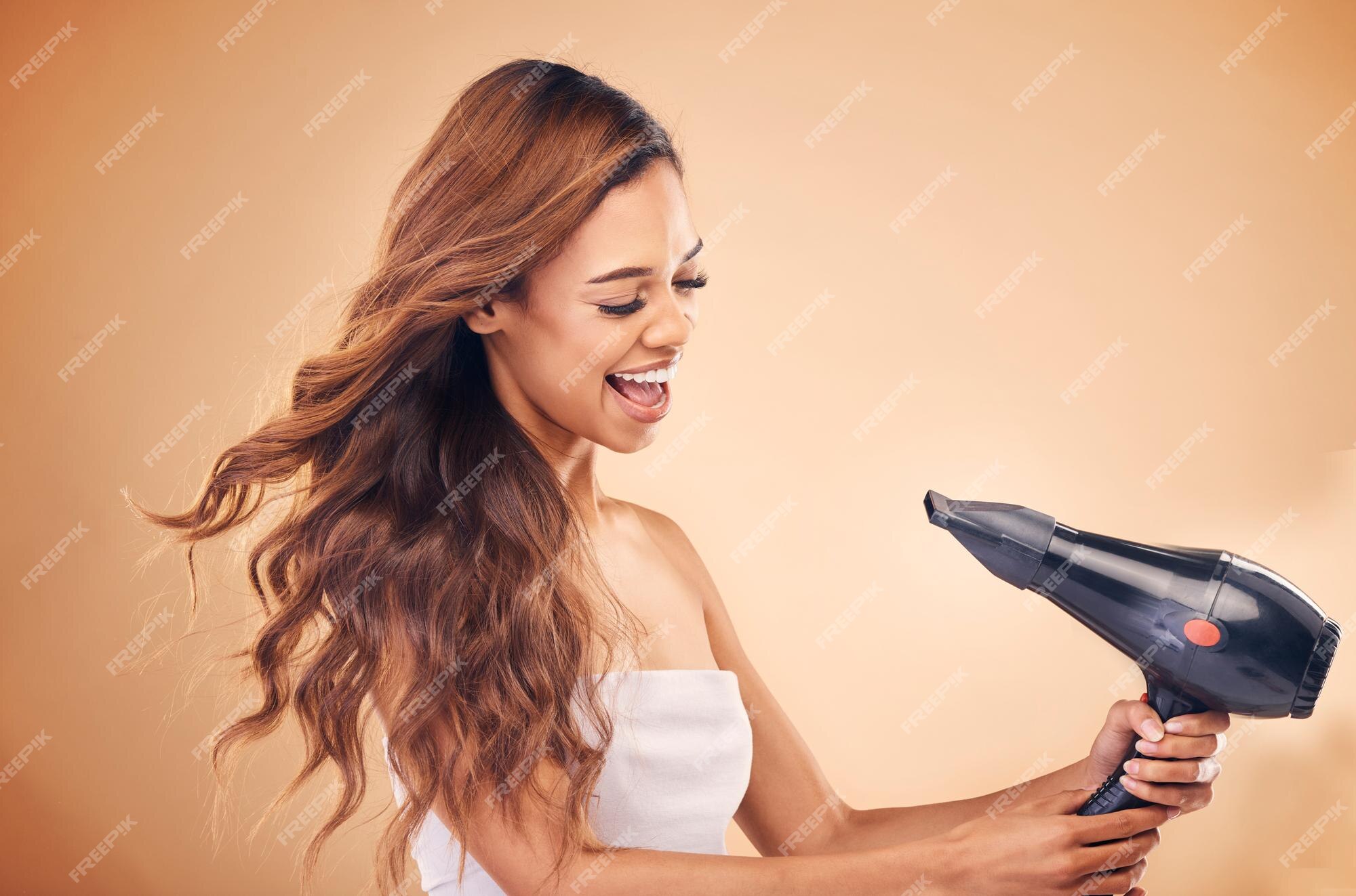 Cabeleireiro alegre, mulher posando com um secador de cabelo nas