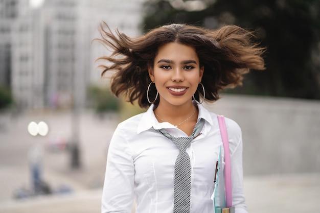 Vento soprando cabelo de linda garota africana ao ar livre