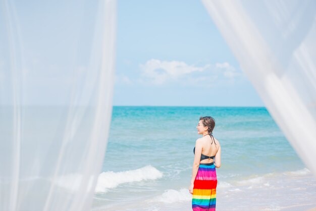 Vento soprar cortinas brancas no mar de areia, conceito de férias de verão.