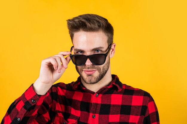 Veo que los hombres visten a un joven apuesto con camisa a cuadros y anteojos, un hombre elegante usa ropa informal, un hombre barbudo con cerdas en la cara sin afeitar, concepto de barbería de moda y belleza