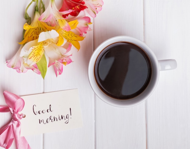 Para ver flores y una taza de café en la mesa