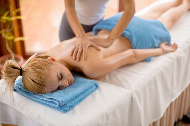 Ver en hermosa mujer rubia disfrutando de un masaje en el spa de salud