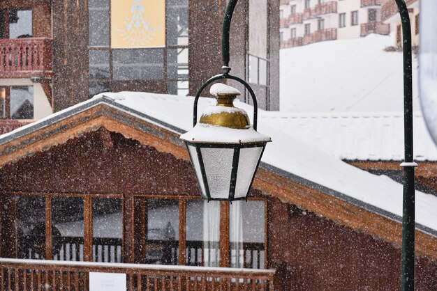 Ver en la luz de la calle y la casa de madera en tiempo de nieve. Estación de esquí Val Thorens en los Alpes franceses. Acogedor y hermoso pueblo en las montañas.