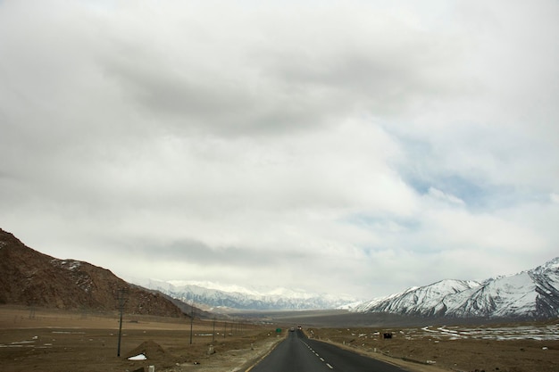 Ver el paisaje al lado de la carretera con los indios conducir un automóvil en la autopista Srinagar Leh Ladakh ir al punto de vista de la confluencia del río Indo y Zanskar en Leh Ladakh en Jammu y Cachemira India en invierno