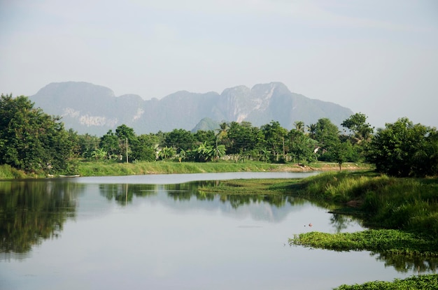 Foto ver el paisaje del elevador de pesca y la máquina de redes de inmersión en el canal en el pueblo pesquero de ban pak pra y la montaña khao oktalu o la montaña the hole en la provincia de phatthalung, en el sur de tailandia