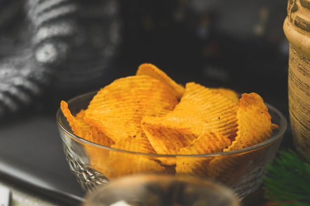 Ver películas solo en casa, comida poco saludable, bocadillos, papas fritas en un tazón, computadora portátil, acogedor fondo de invierno. Foto de alta calidad