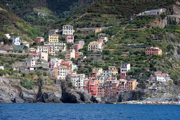 Ver en la pequeña ciudad Riomaggiore desde el barco. Liguria, Cinque Terre. Italia