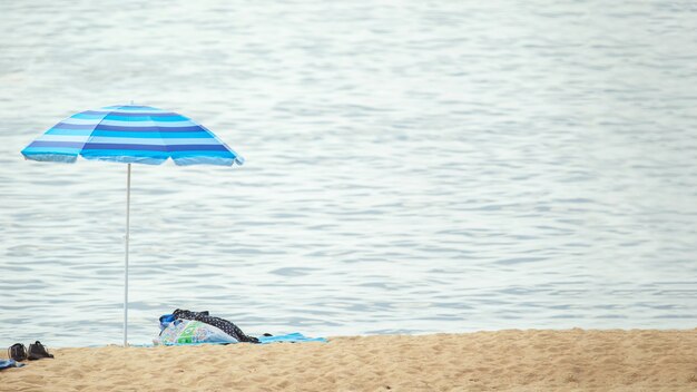 Ver en sombrilla de playa en la costa por el agua
