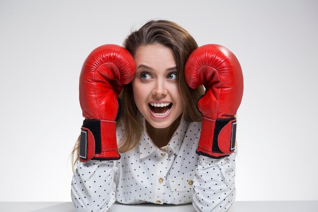 Verängstigtes Mädchen im Polka-Shirt mit Boxhandschuhen