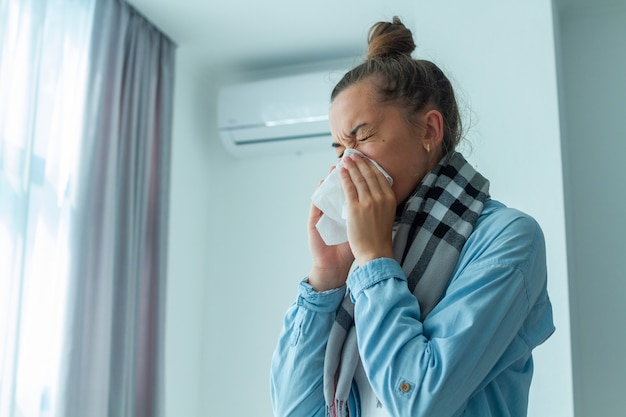 Verärgerte Frau erkältete sich an der Klimaanlage und nieste